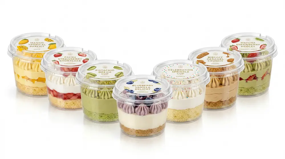 Clear dessert containers with PET/RPET anti-fog lids and round labels for mango, strawberry, pistachio, blueberry, celebration, Biscoff, and matcha desserts.