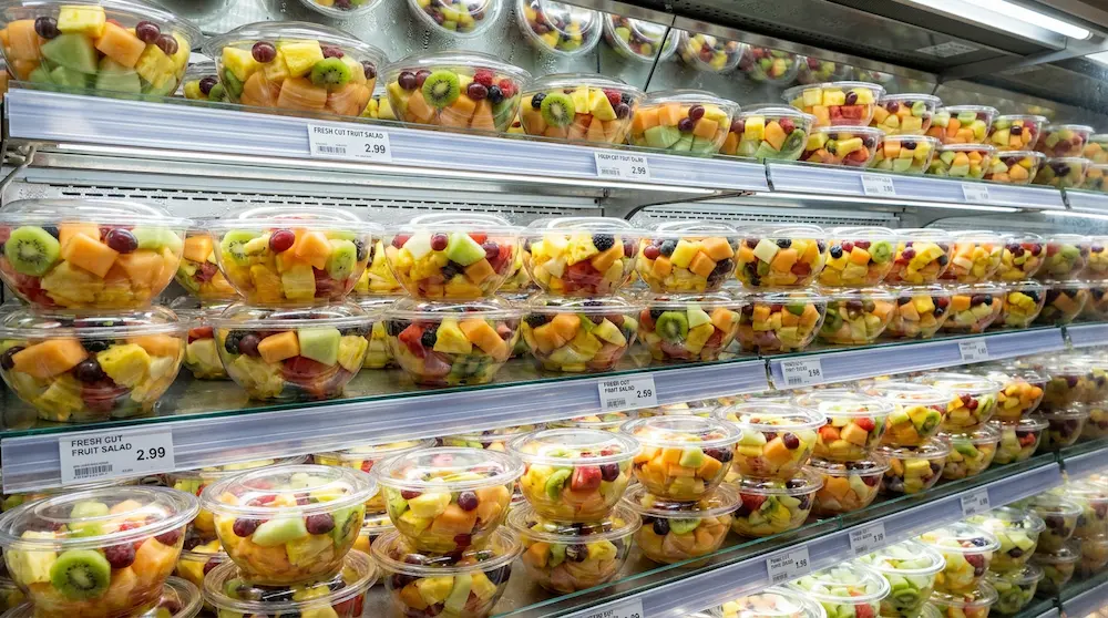 Clear PET bowl for fresh-cut fruit salad in chilled supermarket wall display
