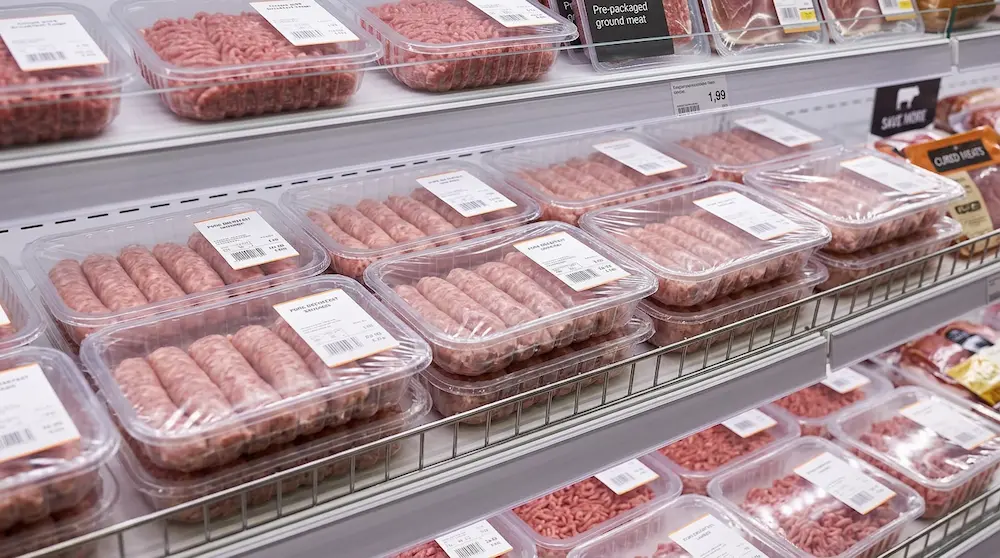 Clear PET meat trays for sausage and minced meat packaging on supermarket shelf