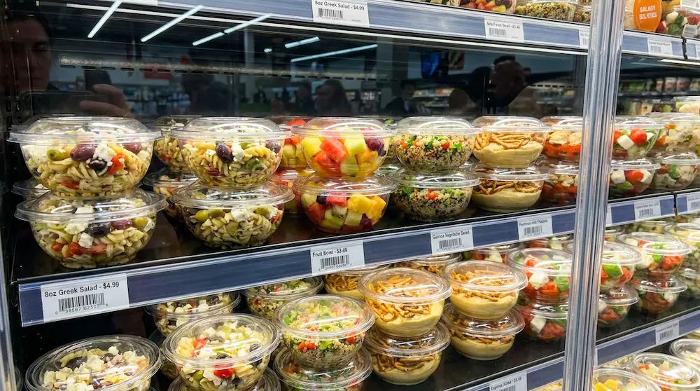 Tamper evident clear rPET round bowls with anti-fog dome lids for salads, fruit bowls, and chilled snacks on a supermarket shelf