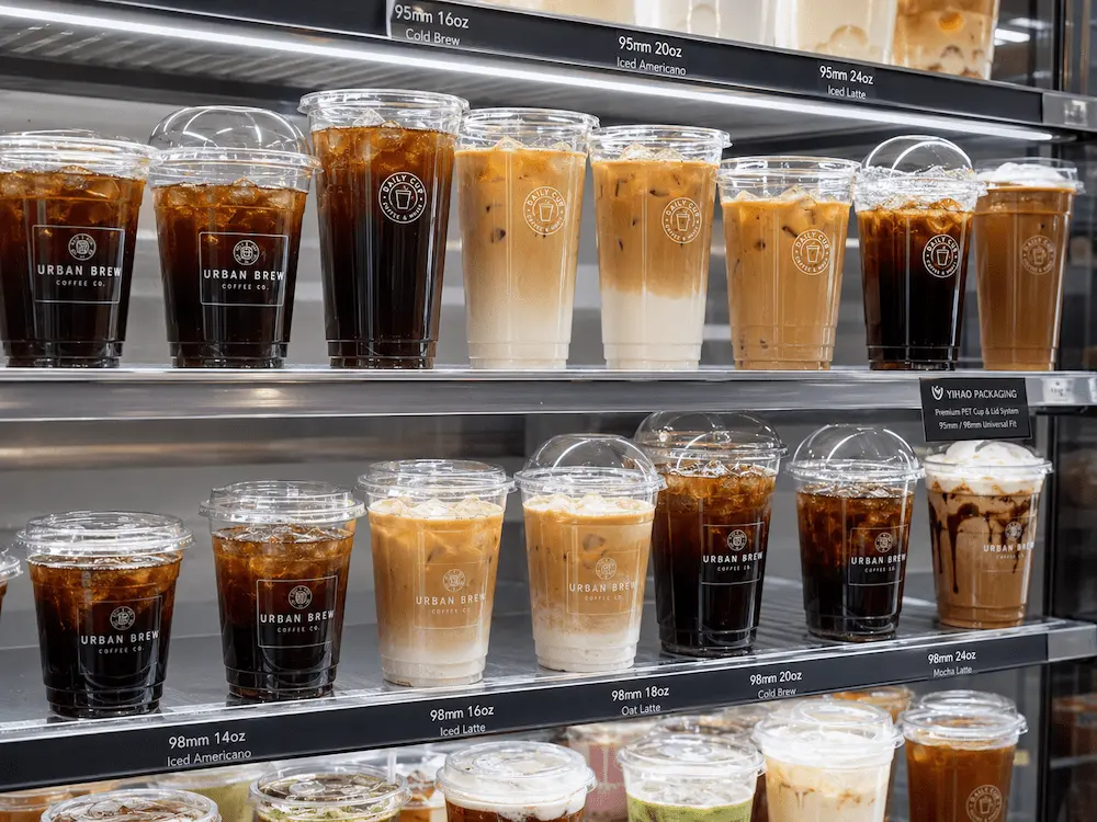 Clear iced coffee cups on retail display shelf with cold brew and iced latte in supermarket grab-and-go section