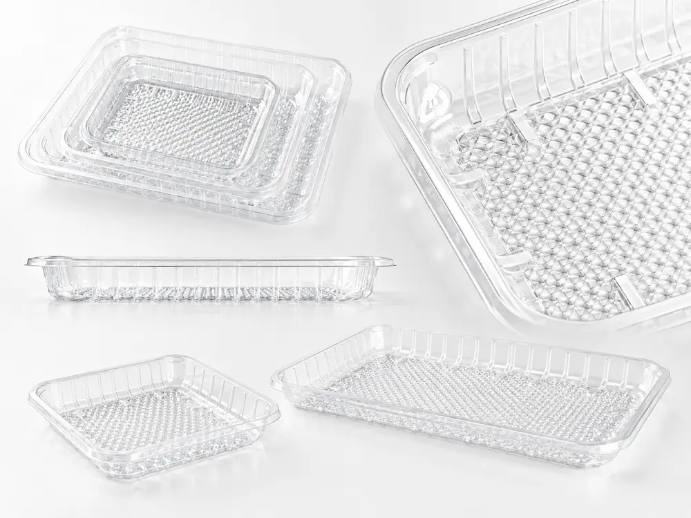 Close-up of clear PET produce tray structure with ribbed sidewalls and textured base
