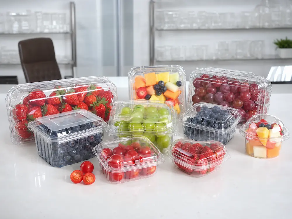 Clear fruit containers, berry boxes, grape packaging, and fresh-cut fruit containers displayed in a showroom