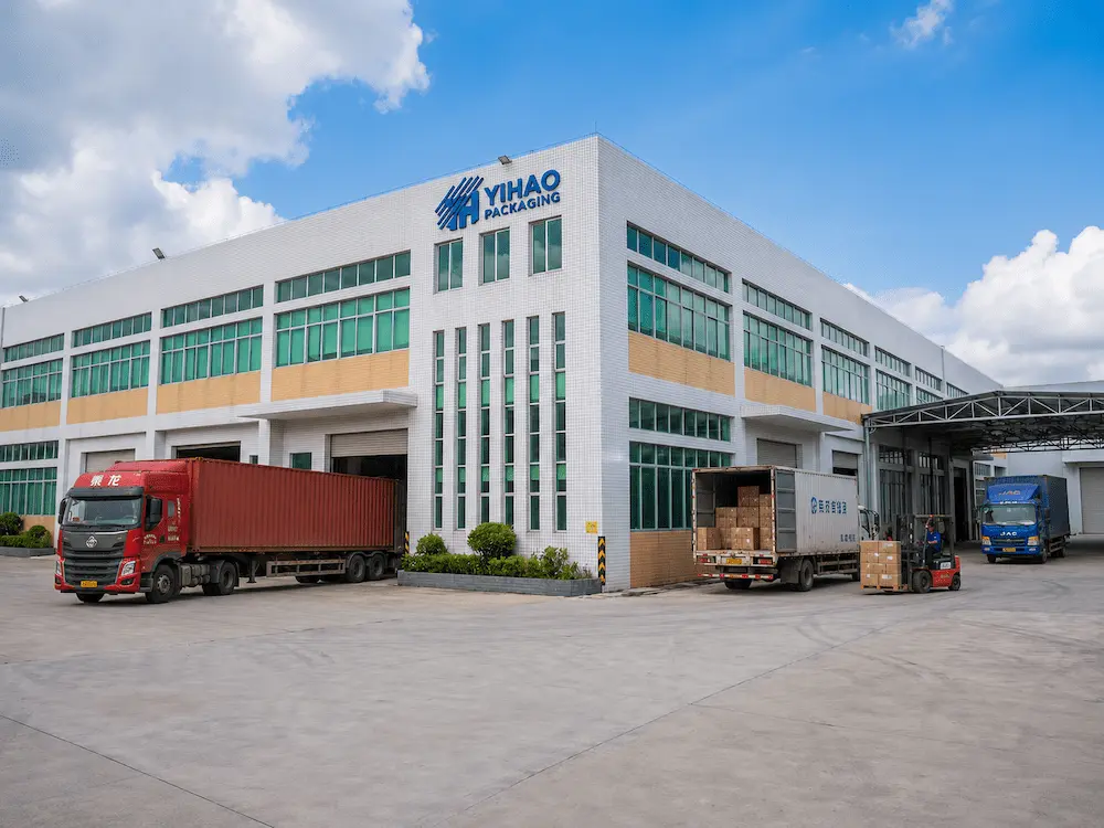 Coffee Cups with Lids FAQ: Materials, Sizes, Uses, and Ordering Questions 7 YIHAO Packaging factory exterior with trucks and cartons for wholesale coffee cups with lids.