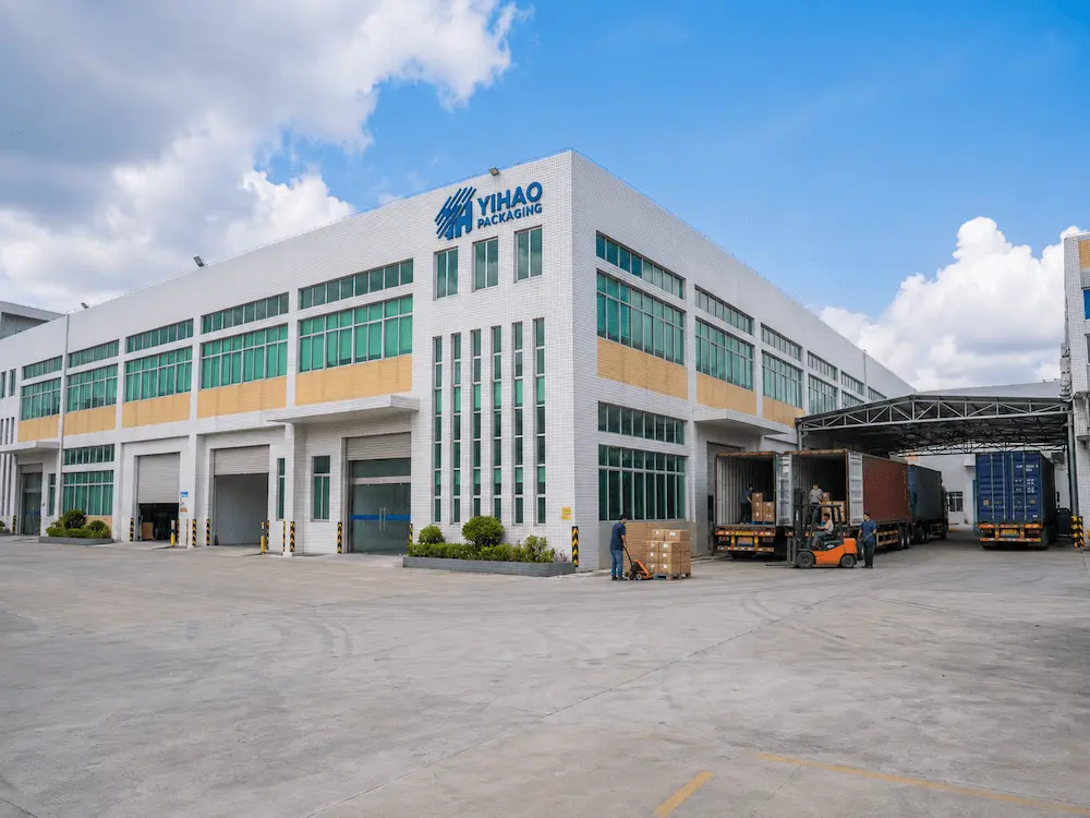 YIHAO Packaging factory exterior with loading trucks for custom iced coffee cups and PET packaging supply.