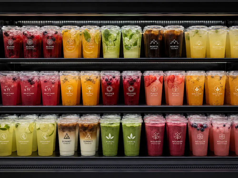 Bulk cold cups displayed in a supermarket refrigerated cabinet with colorful ready-to-drink beverages