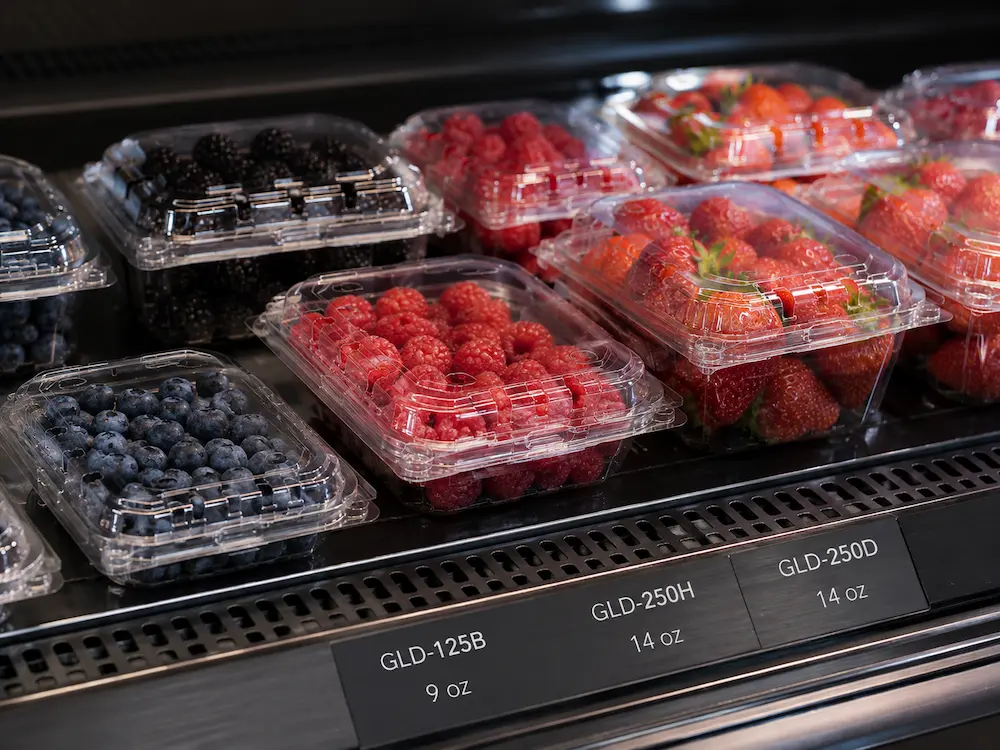 Vented Berry Containers vs Alternative Packaging: How Buyers Should Choose 4 Vented berry containers in chilled retail display with blueberries, raspberries, strawberries, and blackberries