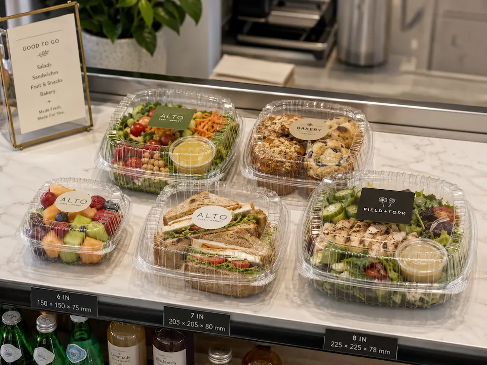 Clear hinged deli containers for cafe grab-and-go salads, sandwiches, fruit, and bakery portions.