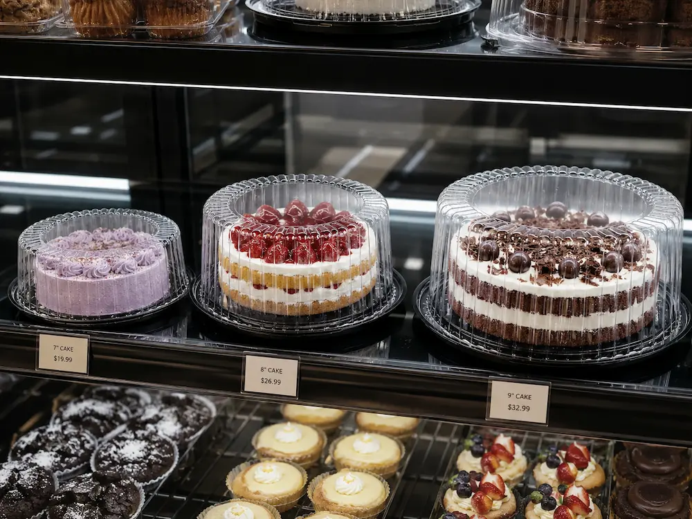 Cake Containers: Buyer Guide for Food Packaging Teams 4 Clear PET cake containers displaying 7 inch, 8 inch, and 9 inch cakes in a bakery case