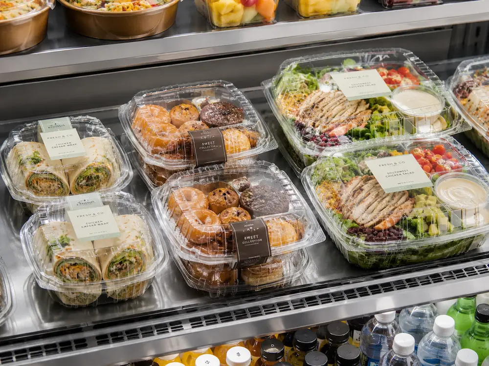 Produce Packaging Manufacturer: Buyer Guide for Food Packaging Teams 4 Clear PET clamshell food containers in refrigerated display for wraps pastries and salads