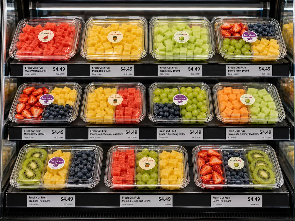 Clear PET grab-and-go fruit containers displayed in a refrigerated retail shelf
