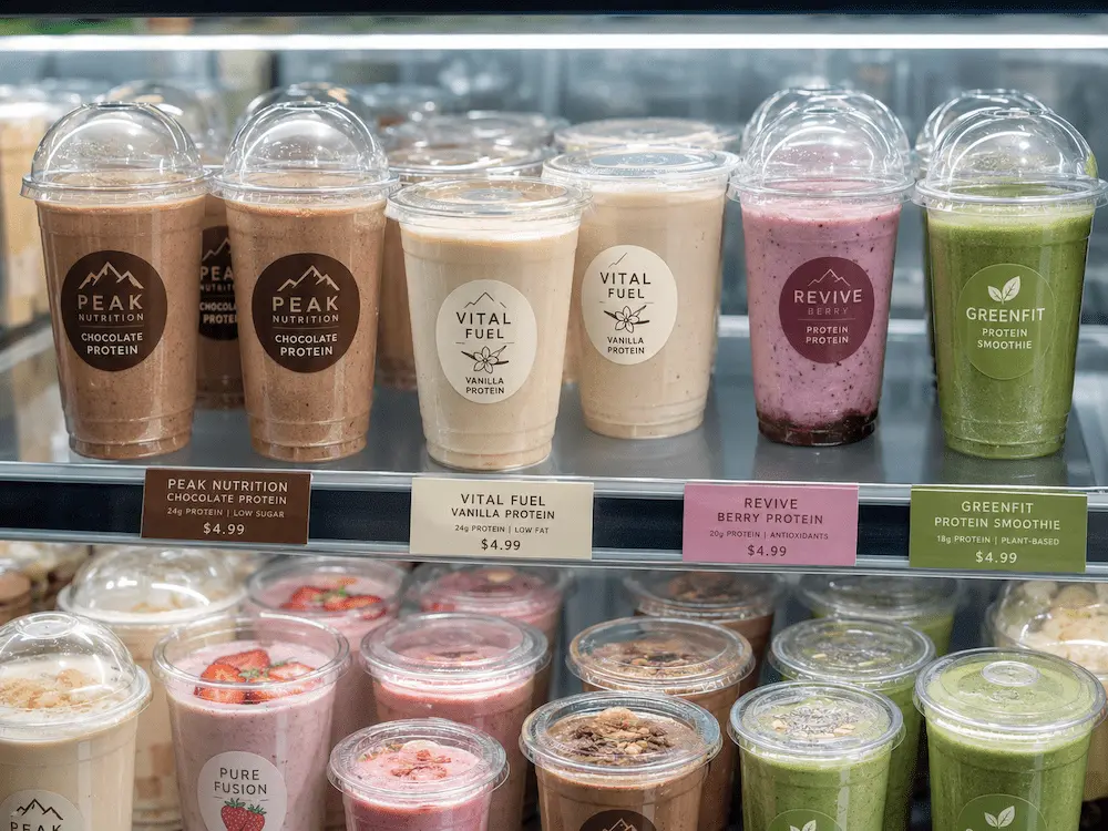 Clear PET protein drink cups with dome lids for smoothies, protein shakes, and functional cold beverages in a retail display