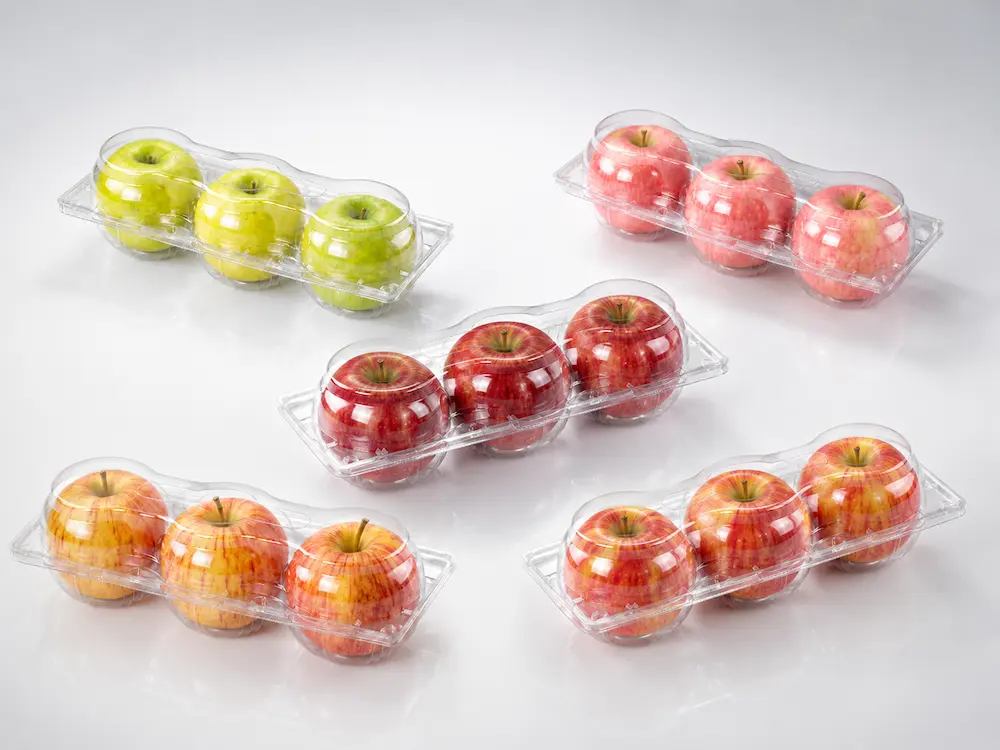 Clear PET three-apple clamshell packaging with red, green, and yellow apples in a premium cool gray studio composition