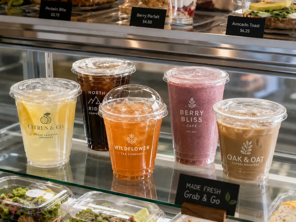 Custom printed cold cups displayed in a cafe grab-and-go beverage case