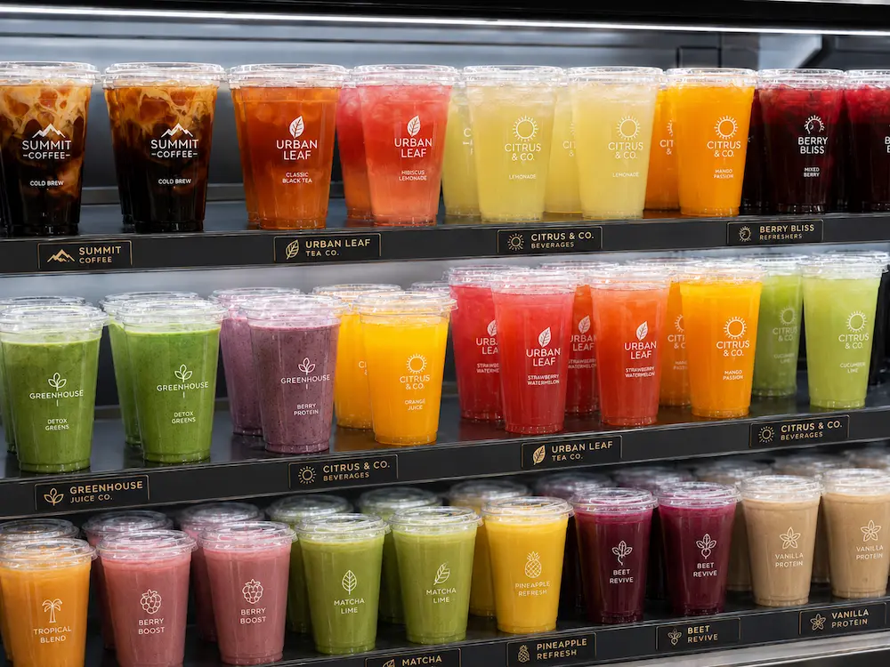Wholesale Custom Cups for Supermarkets, Cafes, Bakeries, and Foodservice Brands 3 Custom printed cold cups displayed in a refrigerated retail case for juices, refreshers, smoothies, and cold drinks