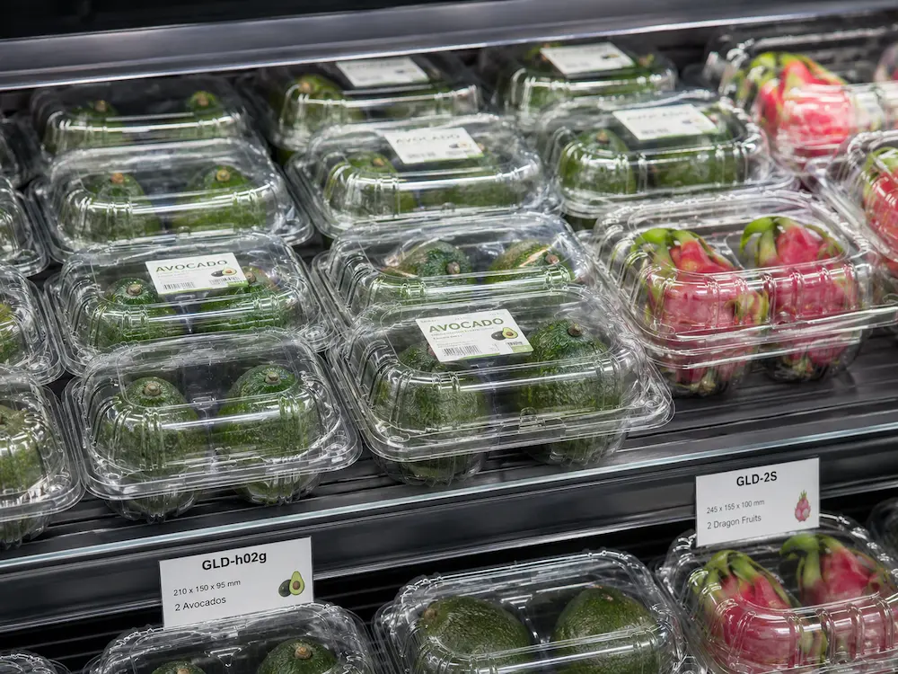 Retail Fruit Containers: Buyer Guide for Food Packaging Teams 8 Retail fruit containers in refrigerated supermarket display with avocado and dragon fruit clamshell packs