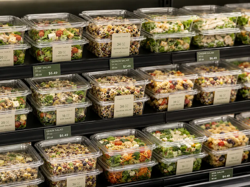 Square PET deli containers arranged on a supermarket chilled shelf for salads and grab-and-go meals