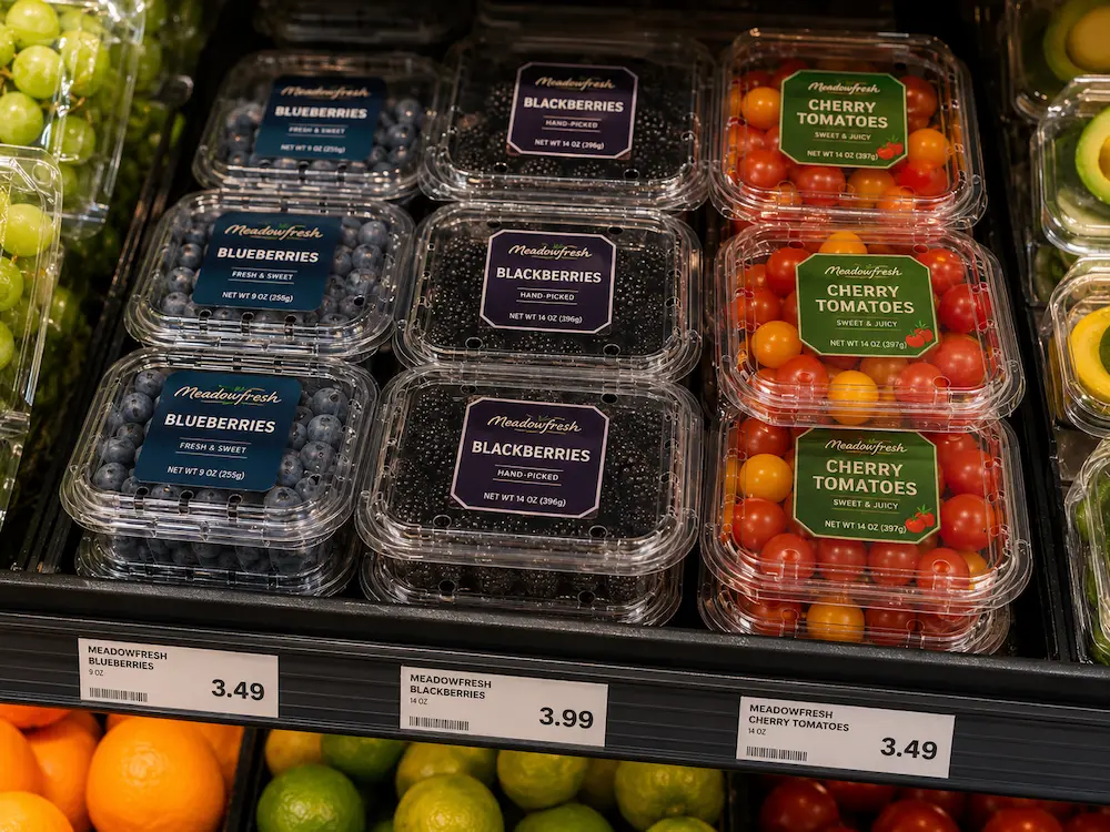 Clear PET fruit clamshell containers displayed on a supermarket fresh produce shelf