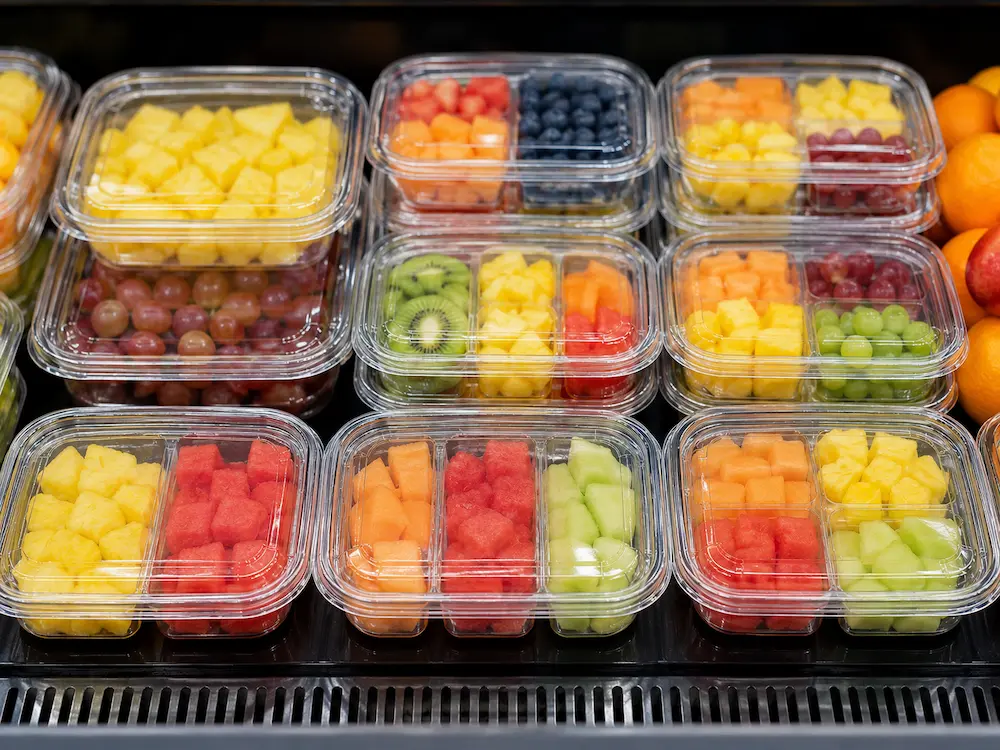 Clear PET fruit containers displayed in a supermarket chilled grab-and-go section