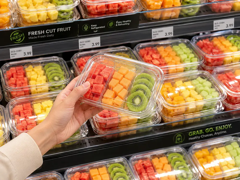 Supermarket grab and go packaging for fresh-cut fruit in a chilled retail display