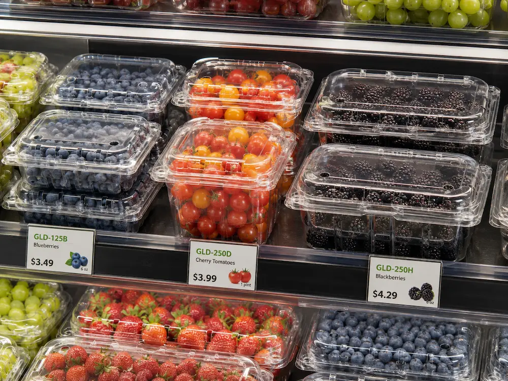 Best Breathable Produce Packaging for Retail Display, Takeaway, and Chilled Food 3 Vented fruit clamshells displayed on a supermarket shelf with blueberries cherry tomatoes blackberries and strawberries