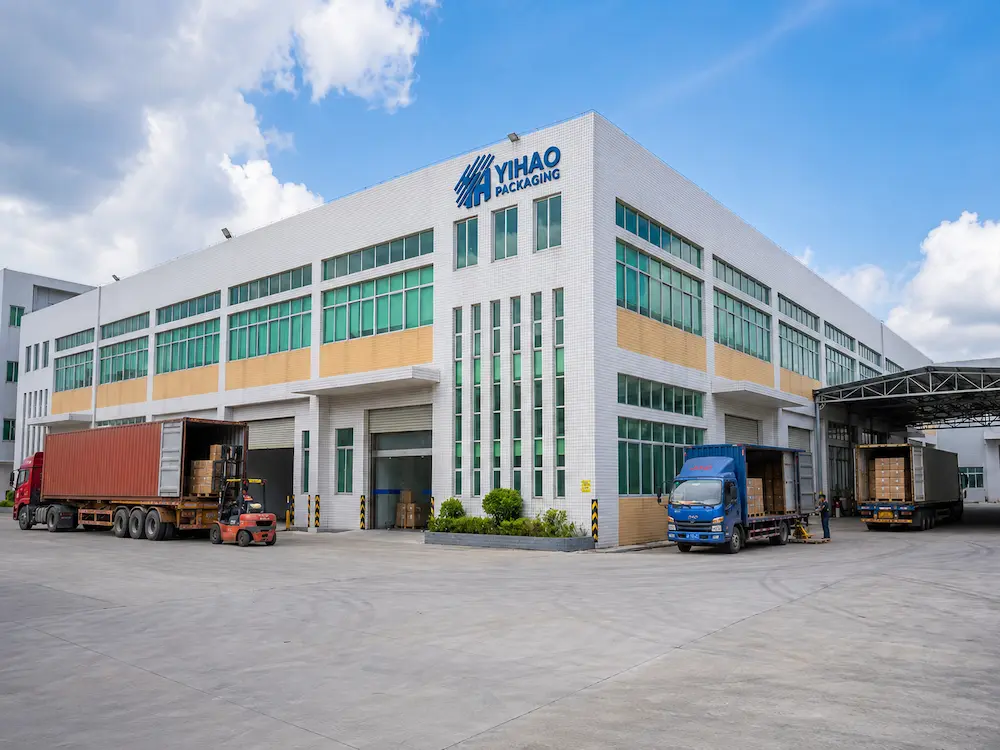 YIHAO packaging factory exterior with loading trucks and export cartons for PET food containers