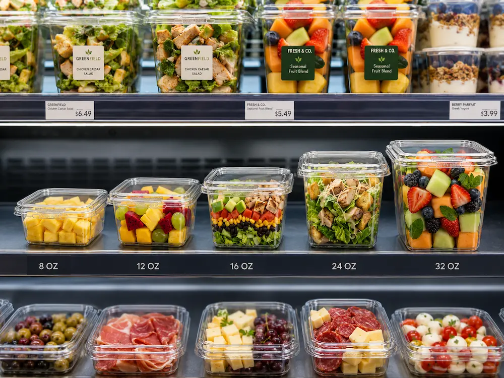 2026 Global Clear PET, rPET and Tamper Evident Food Packaging Buyer Guide 3 Clear PET tamper evident containers displayed in refrigerated retail shelf