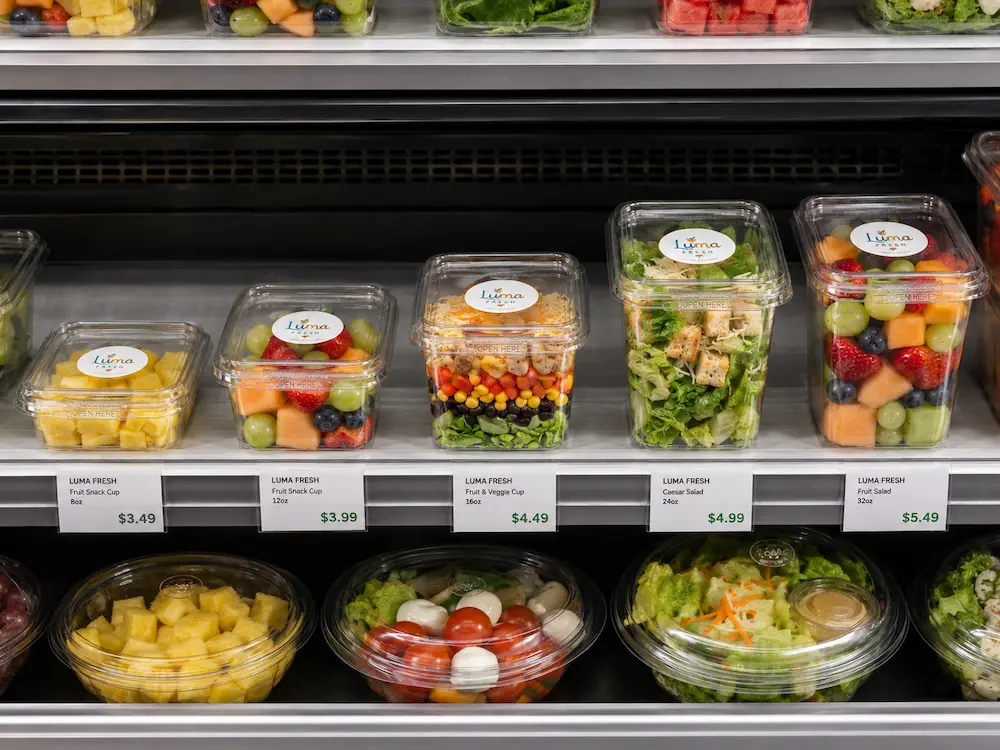 Tamper evident containers in different sizes displayed in a refrigerated retail shelf